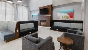 A modern living room with two sofas, a small table, and a fireplace. - Hampton Inn & Suites Salt Lake City Airport (Salt Lake City)