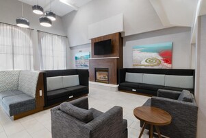Una sala de estar moderna con dos sofás, una mesita y una chimenea.