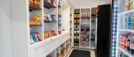 Et velorganiseret spiskummer med hylder fyldt med snacks, drikkevarer og andre madvarer.