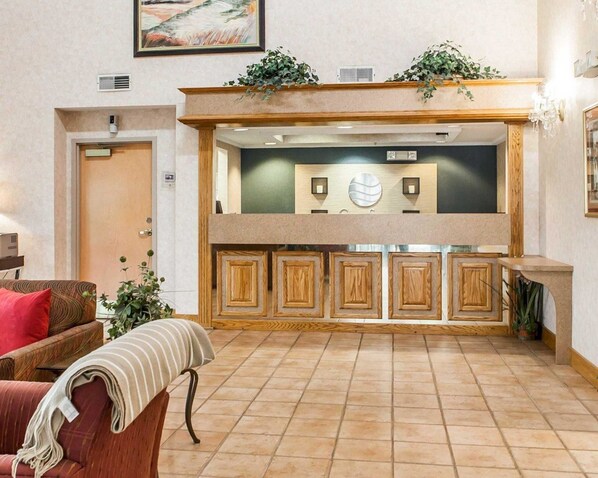 A spacious lobby with a high ceiling, a central fireplace, and a seating area with a sofa and armchairs. - Econo Lodge Newport Smoky Mountains Gateway (Newport)