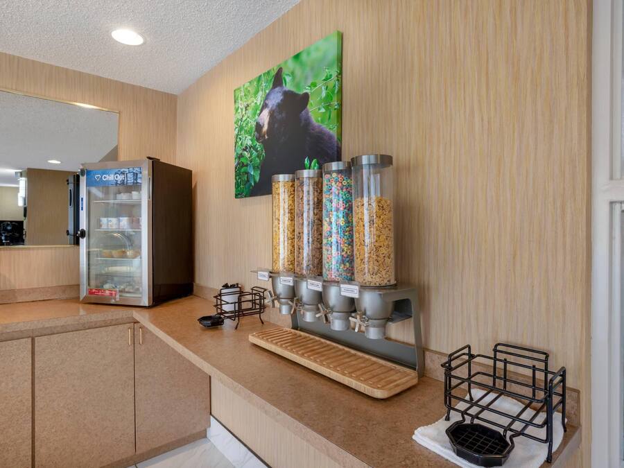 A kitchenette with a refrigerator, a coffee machine, and a cereal dispenser.