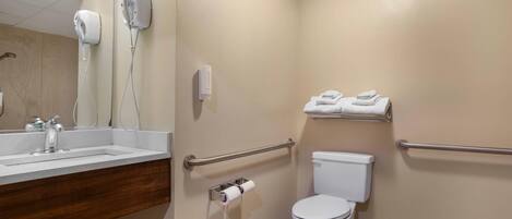 A bathroom with a sink, hand dryer, toilet, and towel rack.