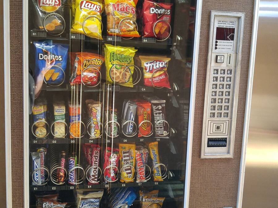 Máquina expendedora llena de diferentes aperitivos y dulces.