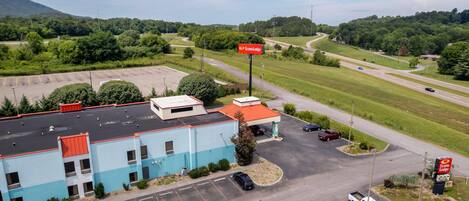 A commercial building with a parking lot, a road with vehicles, and a sign for EconoLodge.
