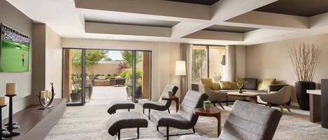A spacious living area with a large window, a sofa set, and a coffee table.