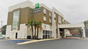 A Holiday Inn Express building with a modern design, large windows, and a parking lot in front. - Holiday Inn Express Columbia NE - Fort Jackson by IHG (Columbia)