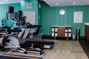 A fitness center with treadmills, a stationary bike, and a wall clock. - Holiday Inn Express Columbia NE - Fort Jackson by IHG (Columbia)