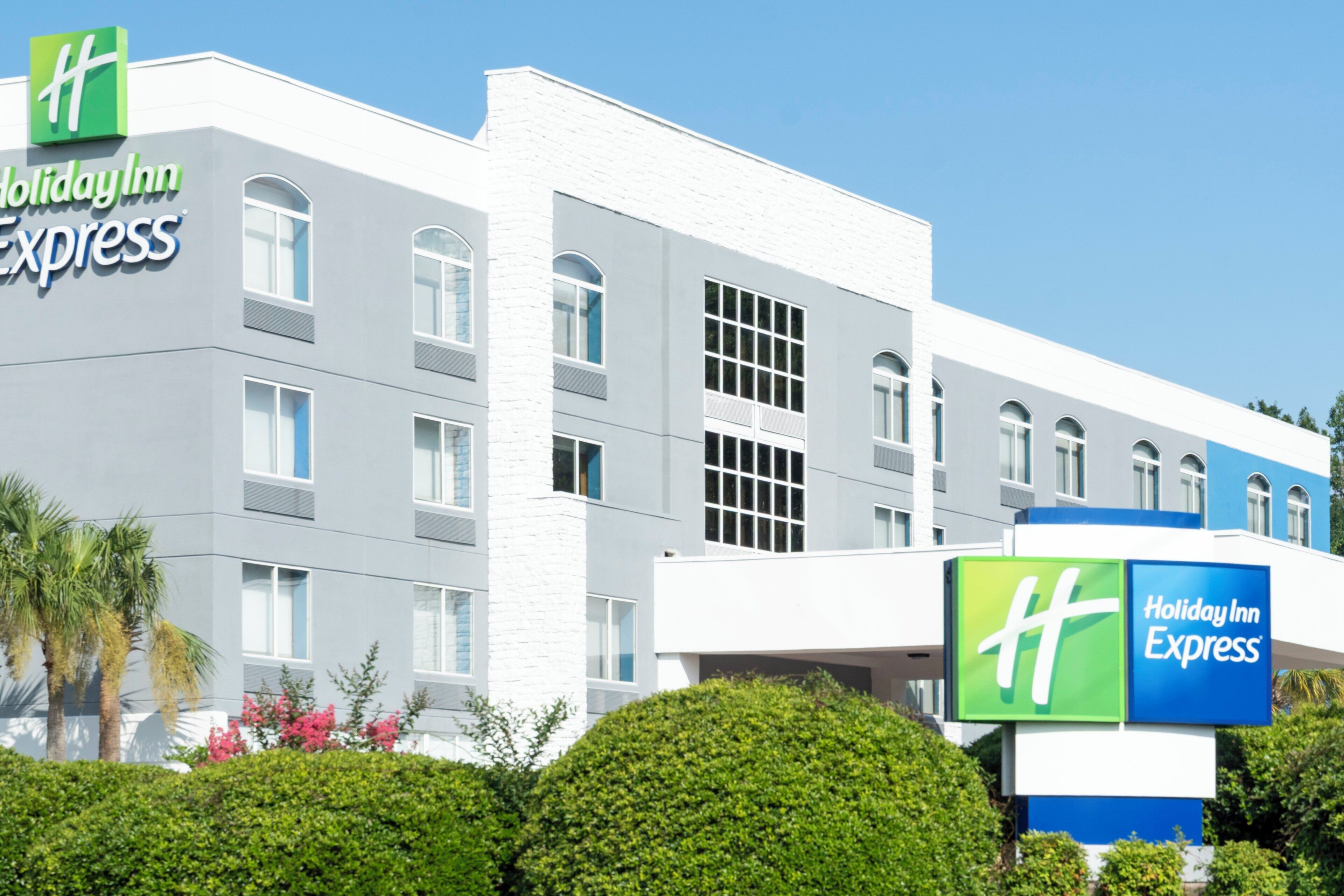 Edifício do Holiday Inn Express com fachada moderna, várias janelas e céu claro.