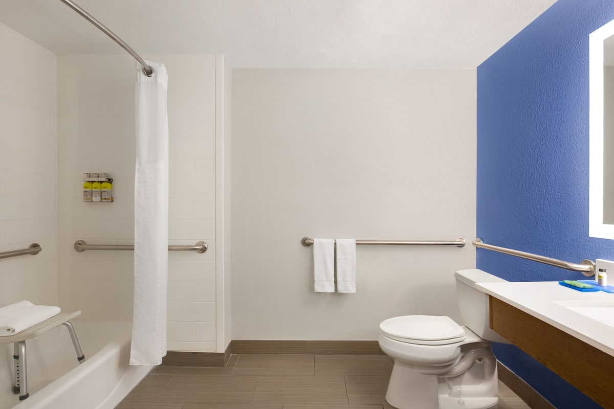 A bathroom with a shower, toilet, and sink.