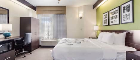 A hotel room with a bed, desk, and wardrobe.