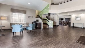 A spacious lobby with a staircase, seating area, and a reception desk. - Sleep Inn Little River - North Myrtle Beach (Little River)
