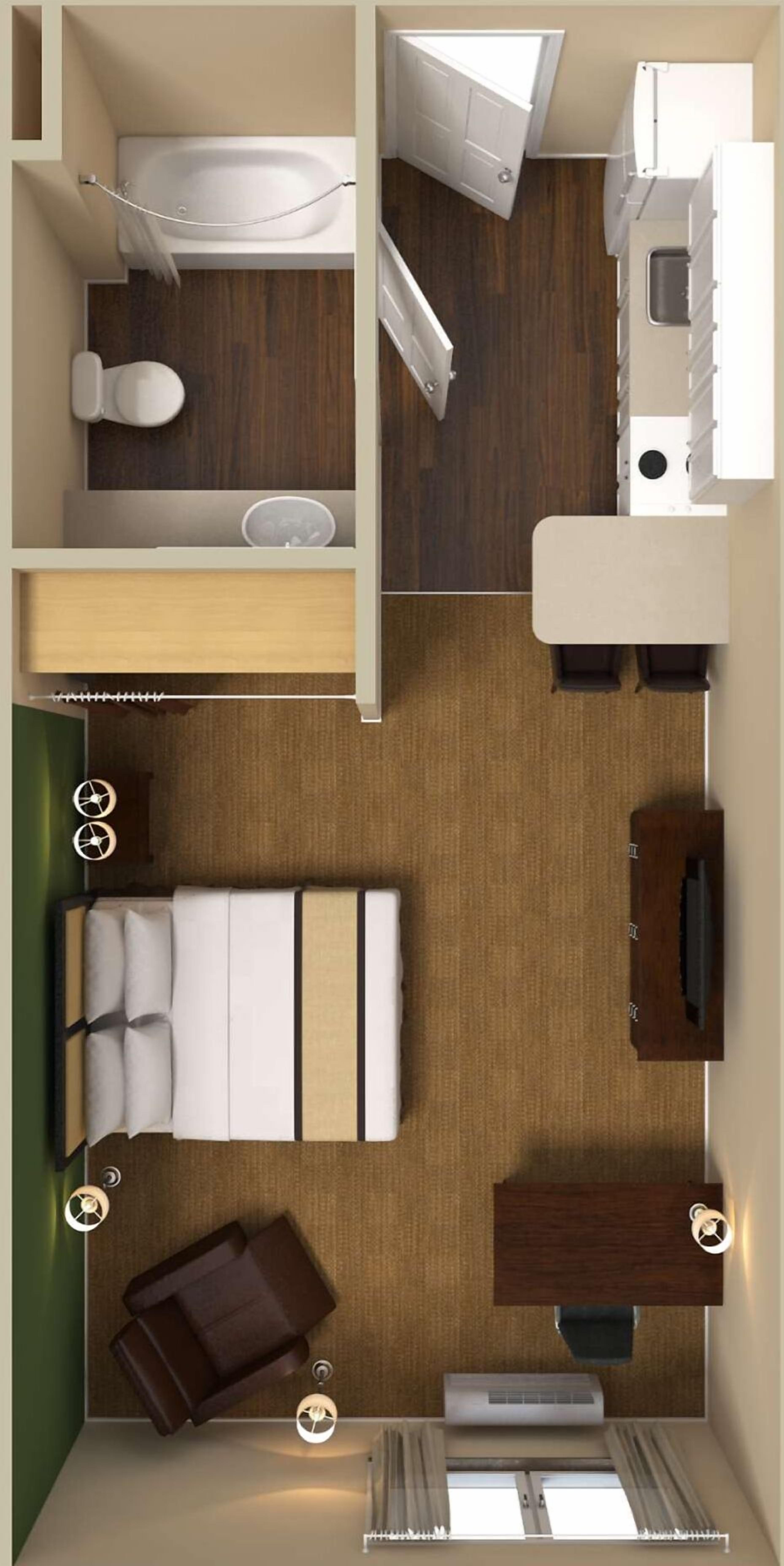 A compact hotel room with a bed, a small desk, a chair, a sofa, a TV, a window, and a bathroom with a bathtub and toilet.