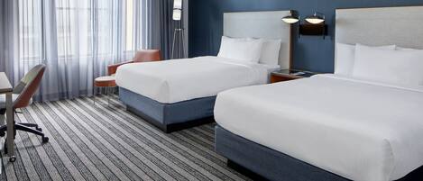 Senger med overmadrass, safe på rommet, skrivebord og blendingsgardiner