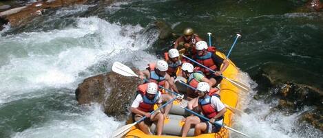 A group of people rafting down a river surrounded by rocks and boulders.