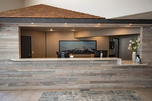 A modern living room with a large flat-screen TV, a piano, and a wooden accent wall.