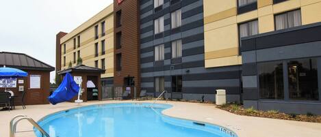 Un hotel con piscina, mobiliario exterior y un letrero de Marriott.