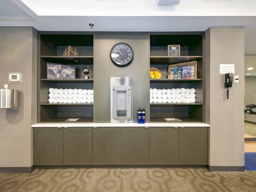 A reception area with a clock, a water dispenser, and a phone.