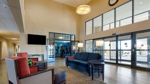 A spacious lobby with a large seating area, a television mounted on the wall, and large windows offering views of the outside. - Comfort Inn Camp Verde I-17 (Camp Verde)