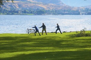Un área verde con un lago y colinas al fondo.