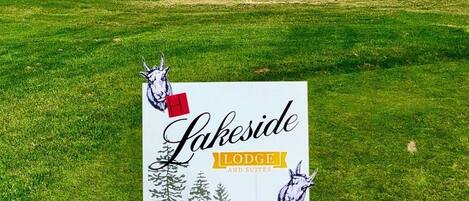 Un terrain de golf avec un panneau indiquant l’emplacement du Lakeside Lodge and Suites.