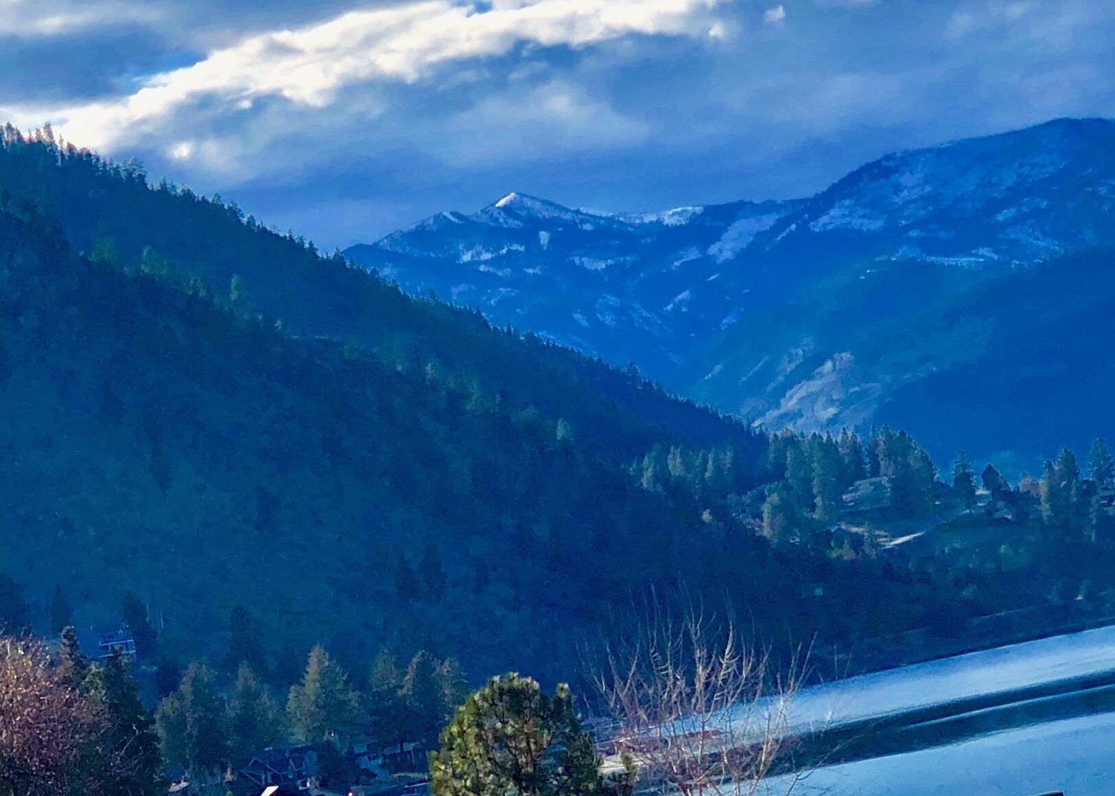 A mountainous landscape with snow-capped peaks and dense forests.