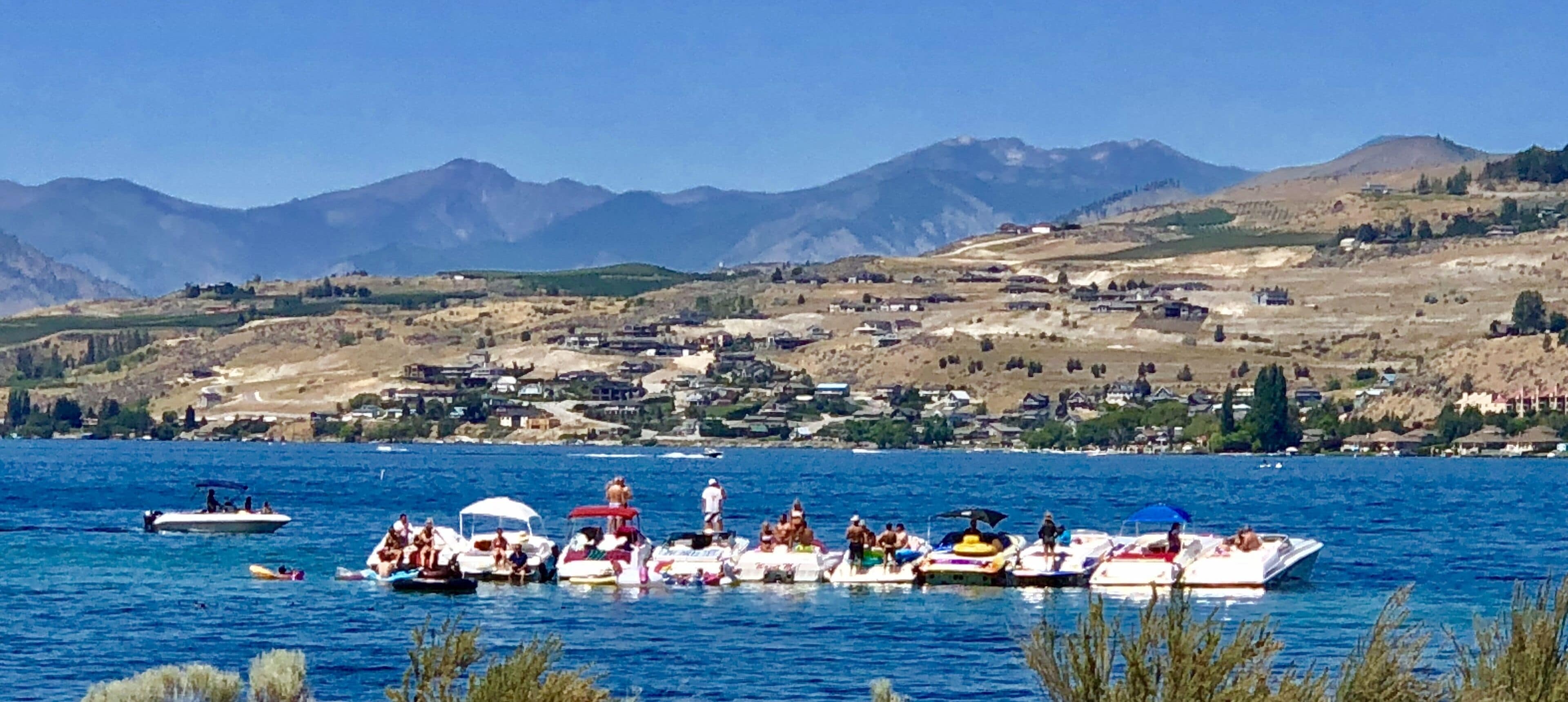 A lake with boats and a mountainous landscape in the background.