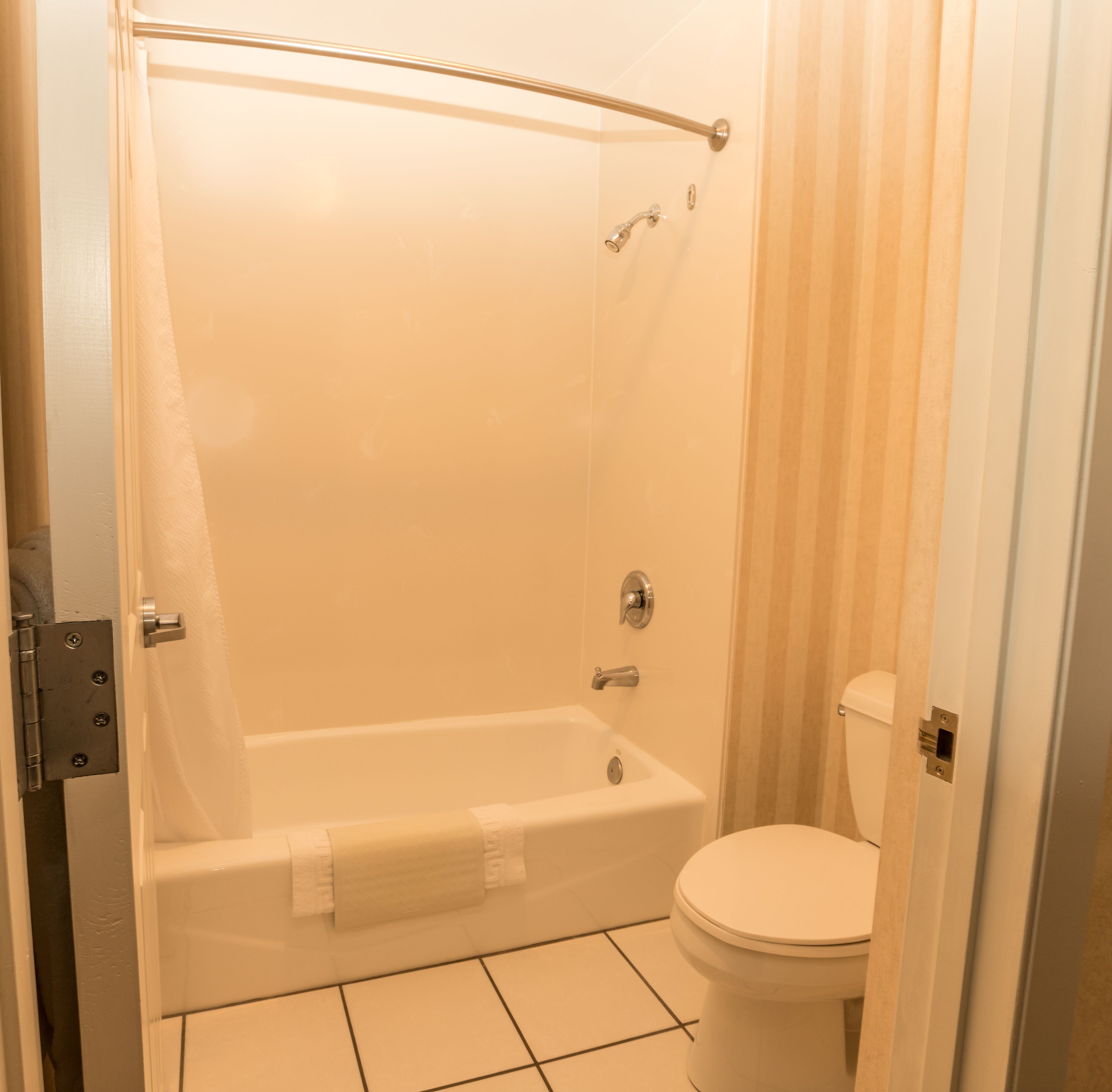 Un baño con bañera, inodoro y cortina de ducha.