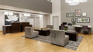 A modern lobby with a reception desk, seating area, and a desk with computers. - La Quinta Inn & Suites by Wyndham Spokane Valley (Spokane Valley)