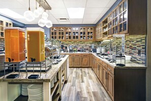 Cocina moderna con armarios de madera, encimera de mármol y zona de café.