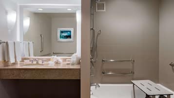 A modern bathroom with a sink, mirror, and shower.