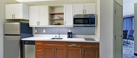A compact kitchen with a refrigerator, microwave, and dishwasher.