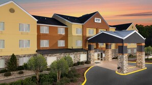 A multi-story hotel with a stone facade, multiple windows, and a parking lot. - Garner Hotel Macon West by IHG (Macon)