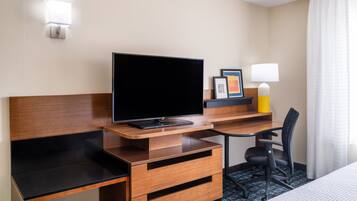 Edredón, escritorio y espacio para trabajar con laptop