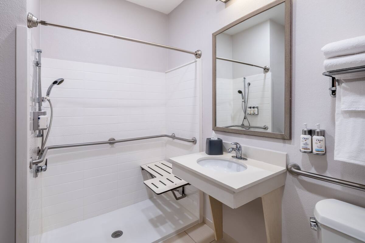A modern bathroom with a bathtub, a sink, a toilet, and a shower.