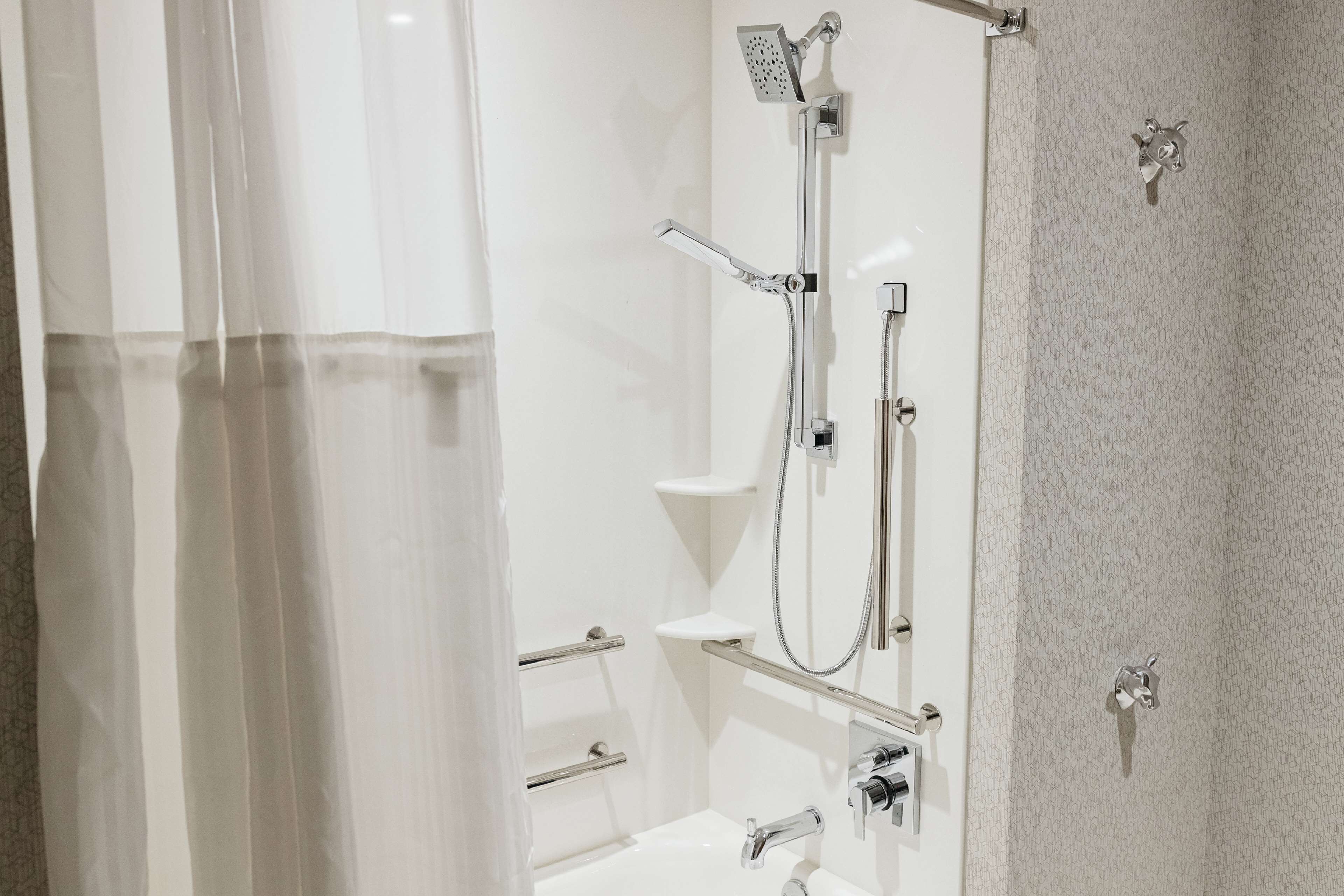 A modern bathroom with a shower, toilet, and sink.