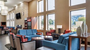 A hotel lobby with blue sofas, armchairs, and a coffee bar. - Comfort Suites Hagerstown Southeast (Hagerstown)