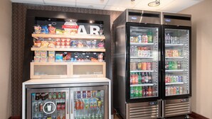 Ein Getränkeautomat mit Snacks und ein Mini-Kühlschrank mit Getränken.