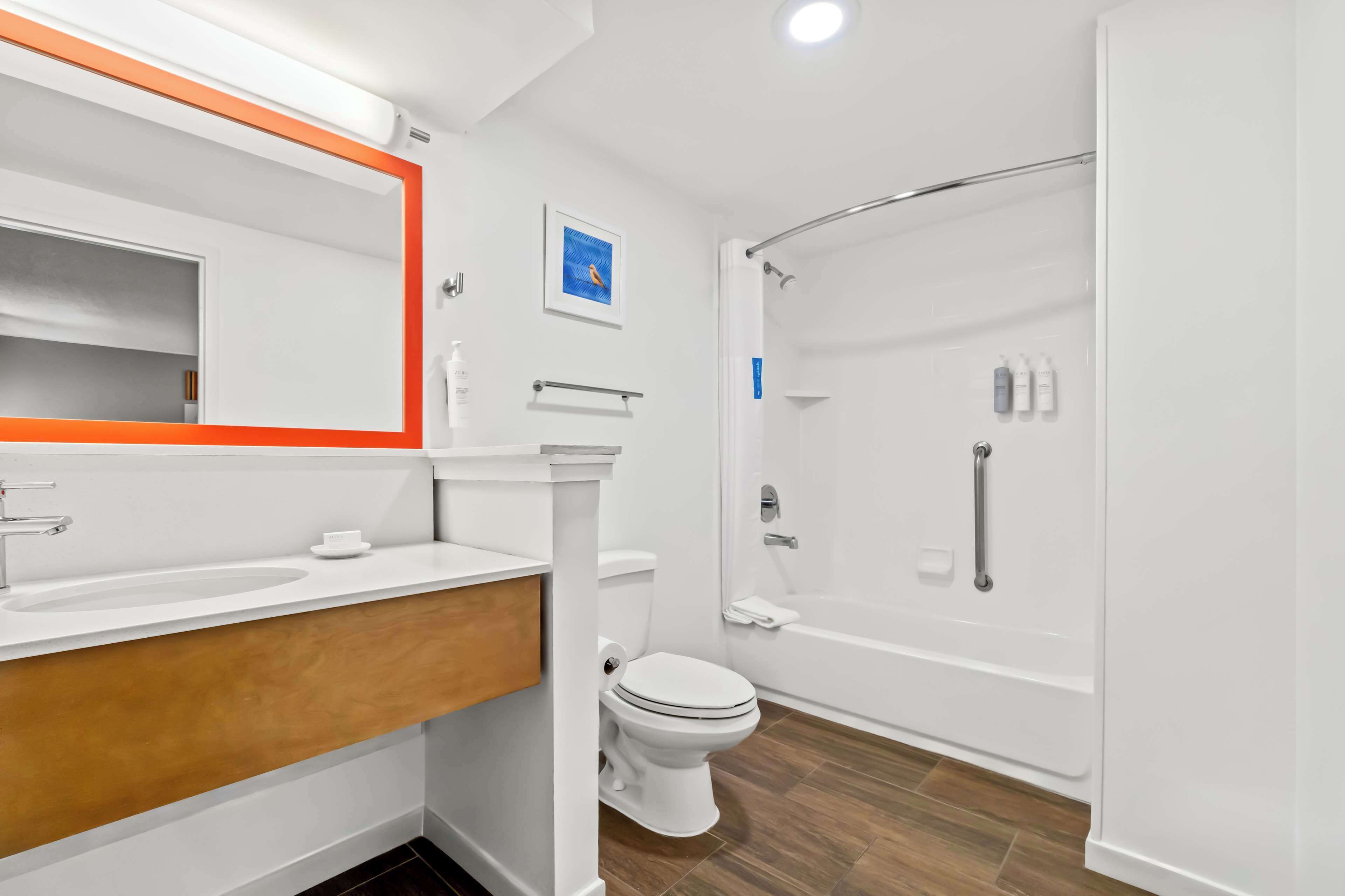 Un baño moderno con lavamanos, inodoro y bañera blancos.