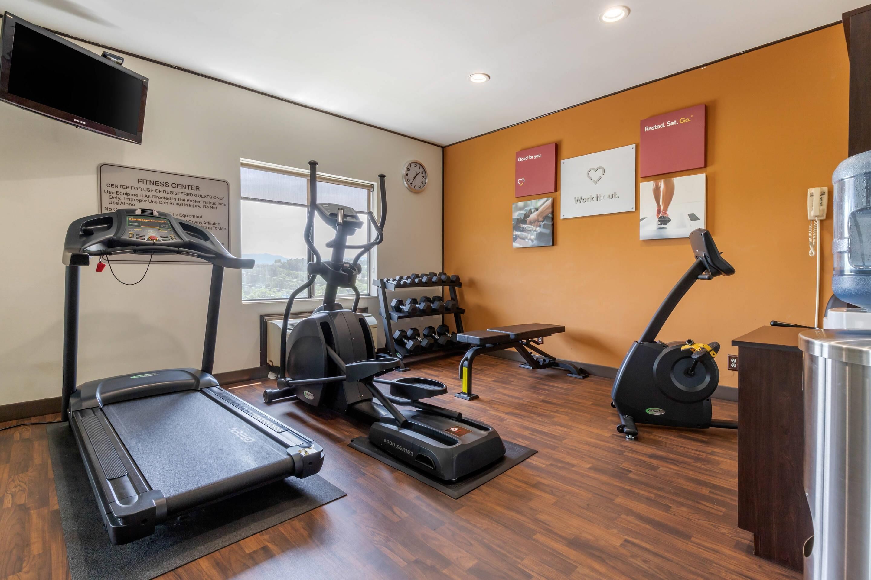A fitness center with treadmills, an elliptical, and a weight rack.