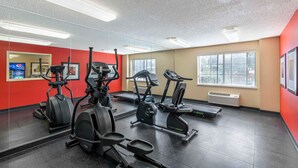 A gym with various exercise equipment, large windows, and a red wall. - Extended Stay America Select Suites Denver Tech Center South (Englewood)