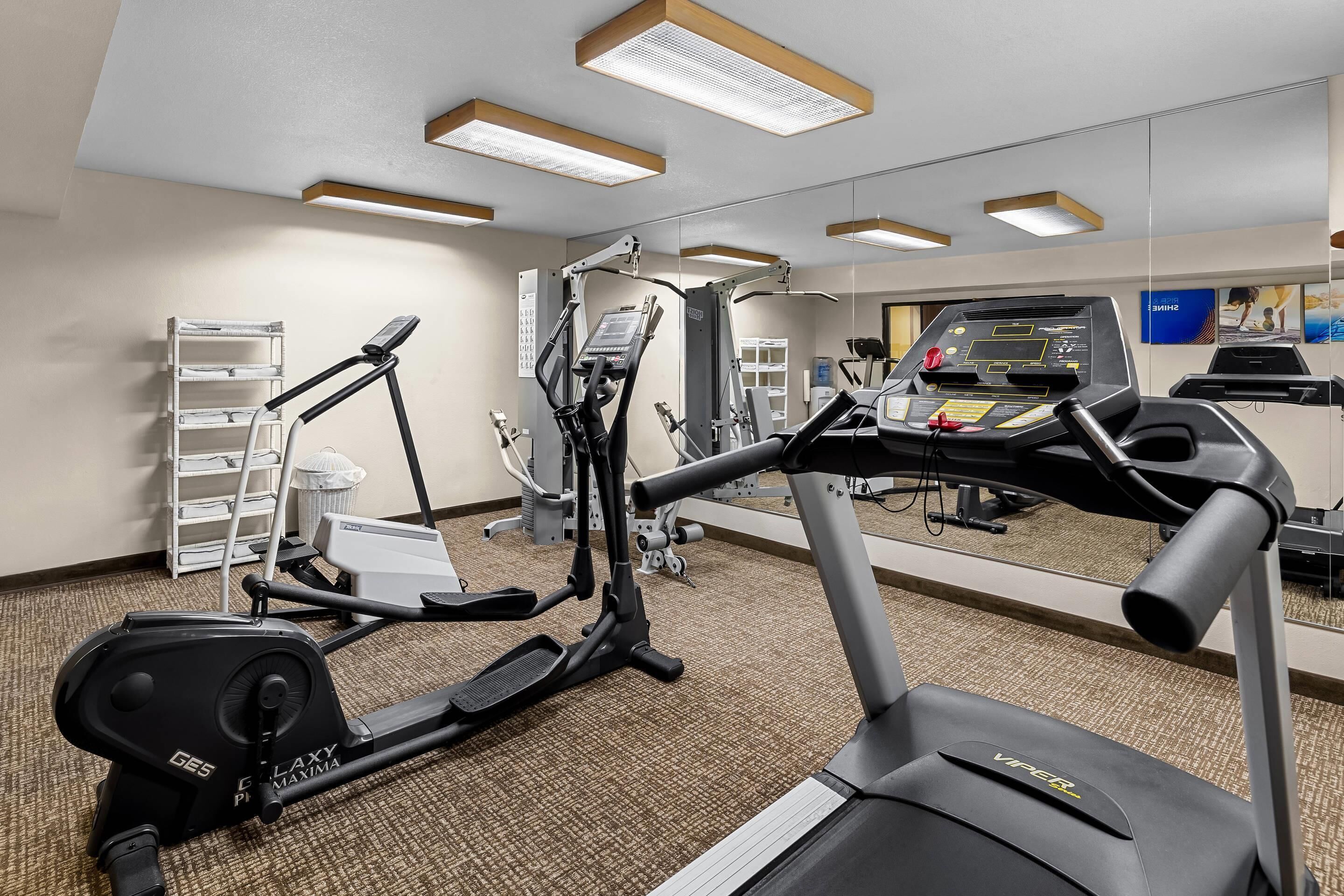A gym with exercise equipment including treadmills, ellipticals, and a stationary bike.