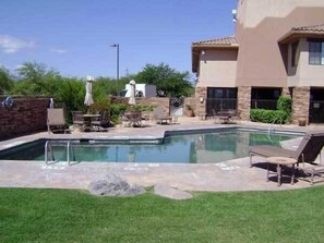 A swimming pool with lounge chairs and a patio area.