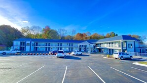 A motel with multiple rooms, a parking lot, and a small building with a balcony. - Kings Inn (LaFayette)