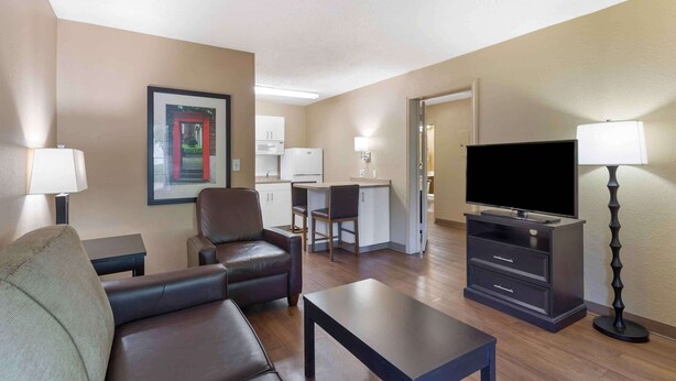 A hotel room with a living area, a kitchenette, a TV, and a desk. - Extended Stay America Suites Washington DC Germantown Town C (Germantown)