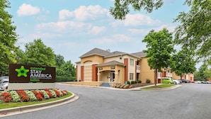 A Stay America extended suites building with a sign, a driveway, and parked cars. - Extended Stay America Suites Washington DC Germantown Town C (Germantown)