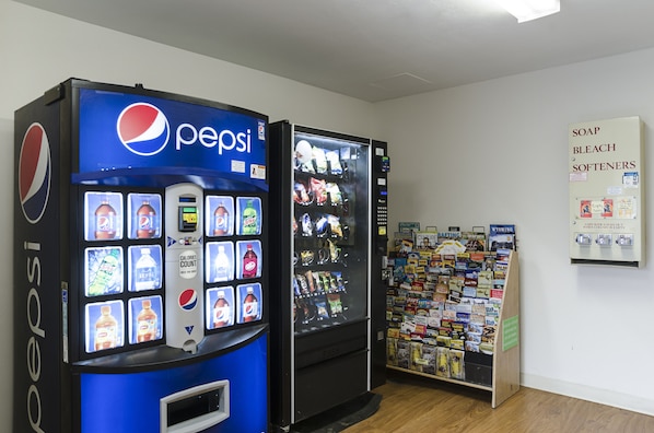 Zona de máquinas expendedoras con Pepsi y una exhibición de jabón y lejía.