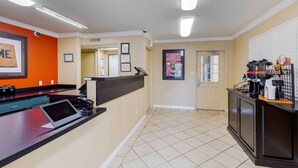 A reception area with a counter, a digital tablet, a phone, and a coffee machine. - Extended Stay America Suites Dallas Las Colinas Carnaby St (Irving)