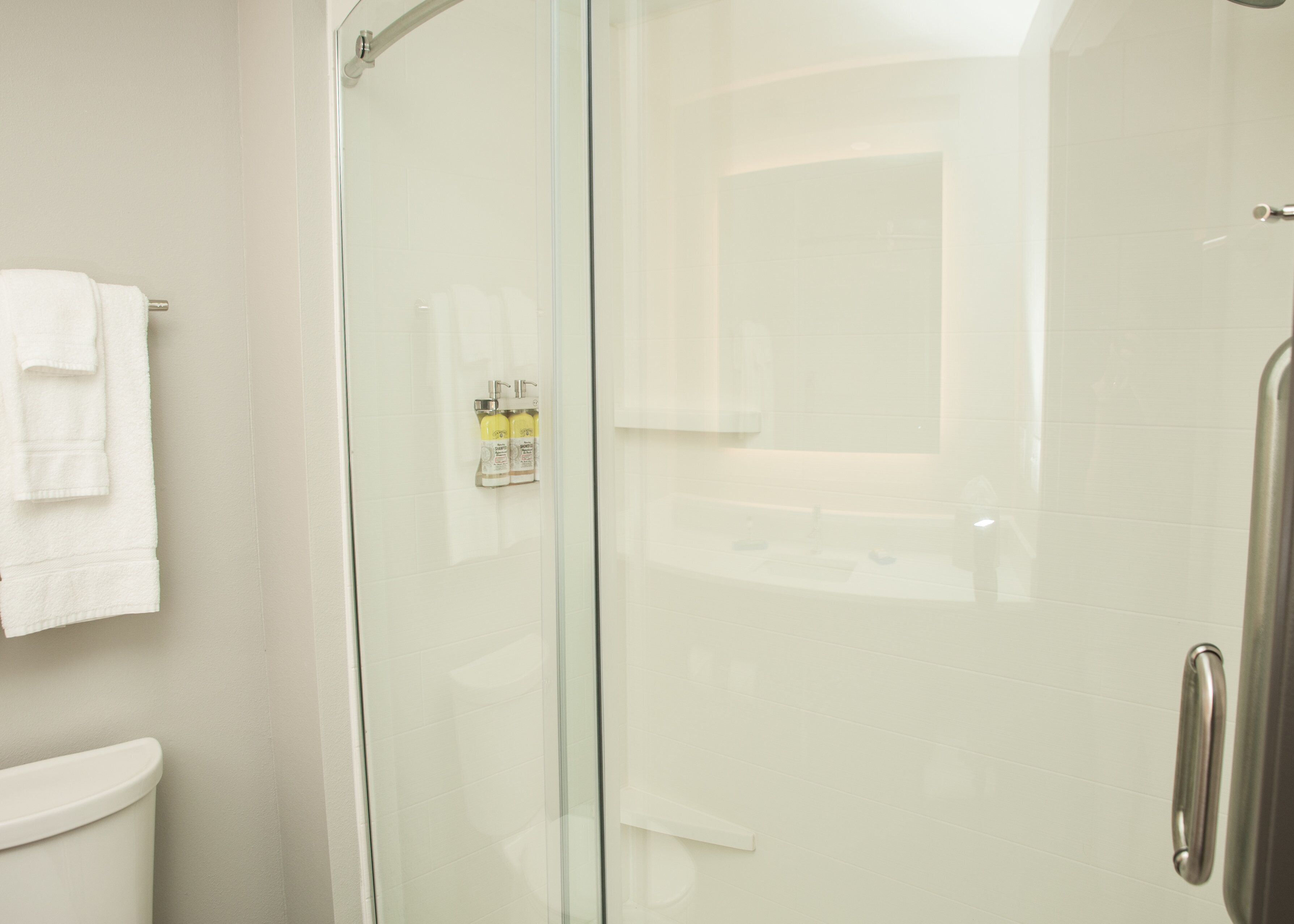 Ein modernes Badezimmer mit einer Duschkabine aus Glas, einer Toilette und einem Waschbecken.