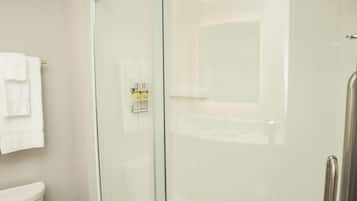 Ein modernes Badezimmer mit einer Duschkabine aus Glas, einer Toilette und einem Waschbecken.