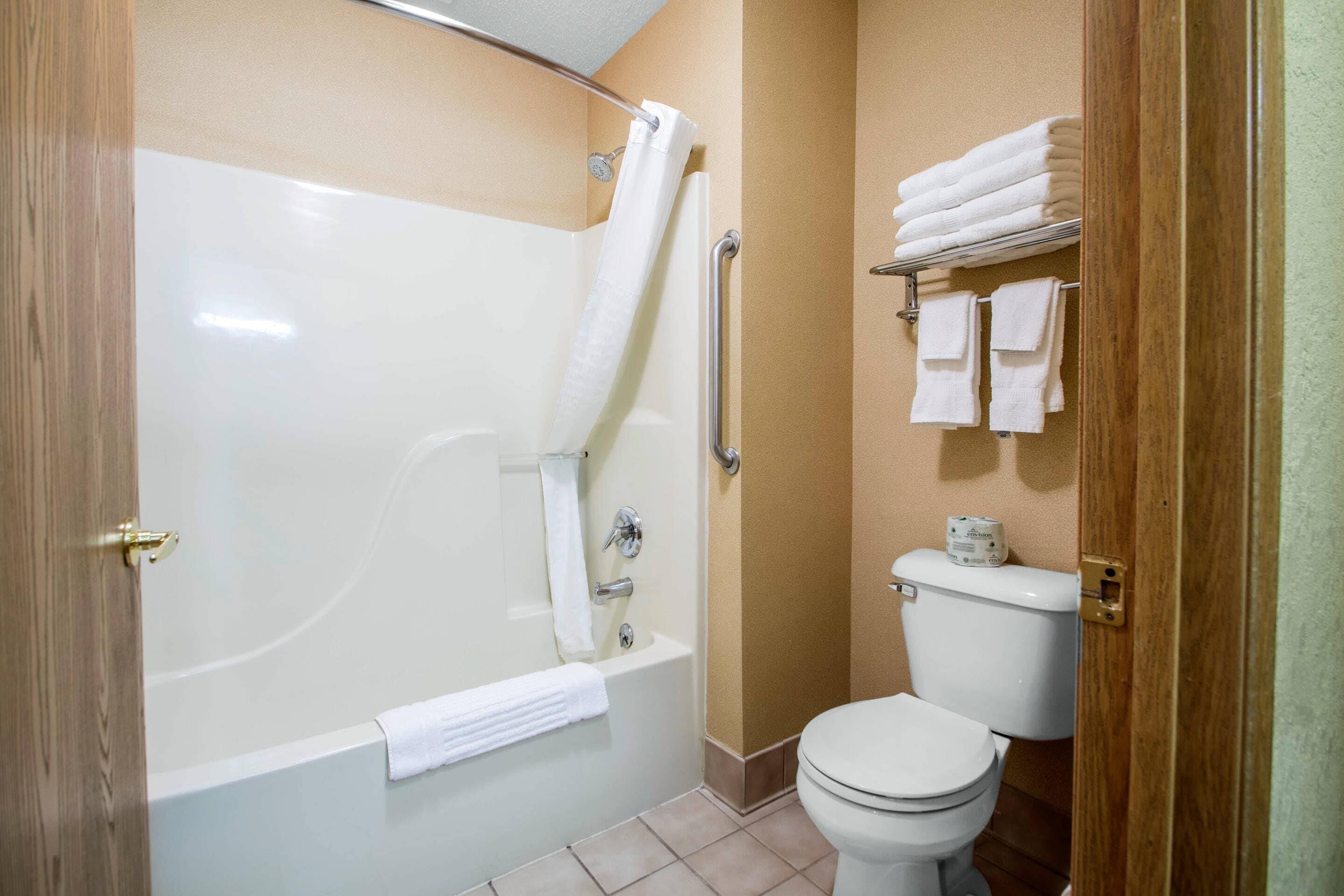 A bathroom with a bathtub, toilet, and a towel rack.